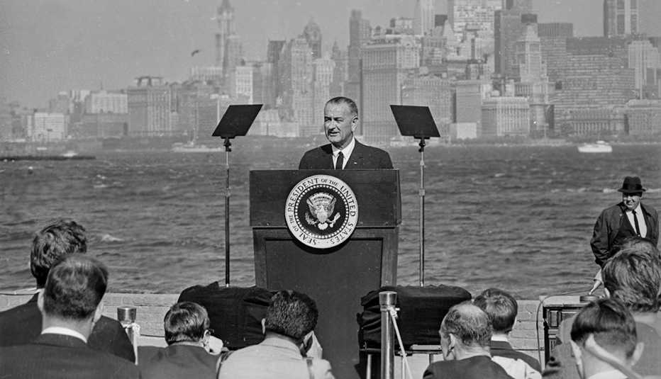 El presidente de Estados Unidos Lyndon Baines Johnson habla al lado de la Estatua de la Libertad, después de haber firmado la nueva ley de inmigración en 1965. 