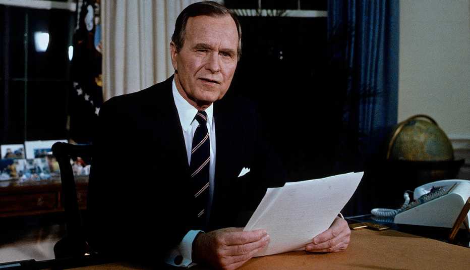 El etonces presidente George H.W. Bush aparece sentado en su escritorio en la Oficina Oval en 1991.