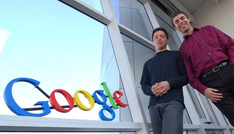 Dos hombres posan frente al logo del buscador Google