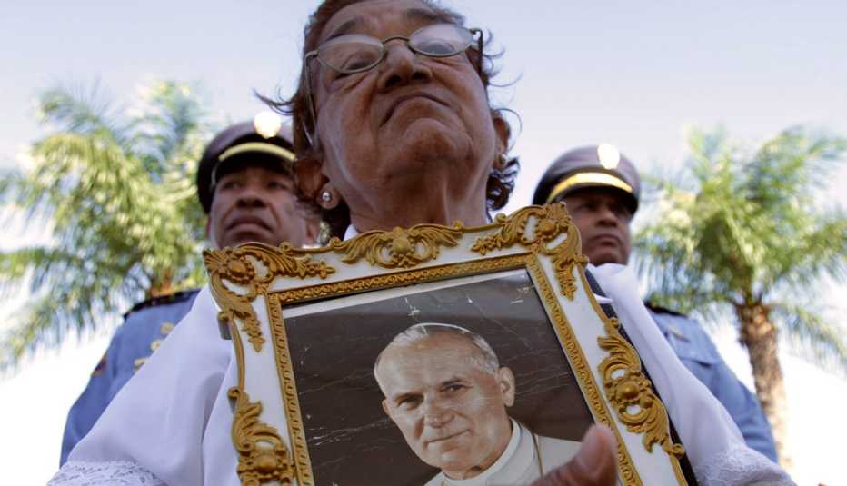 Mujer sostiene una imagen del Papa Juan Pablo II