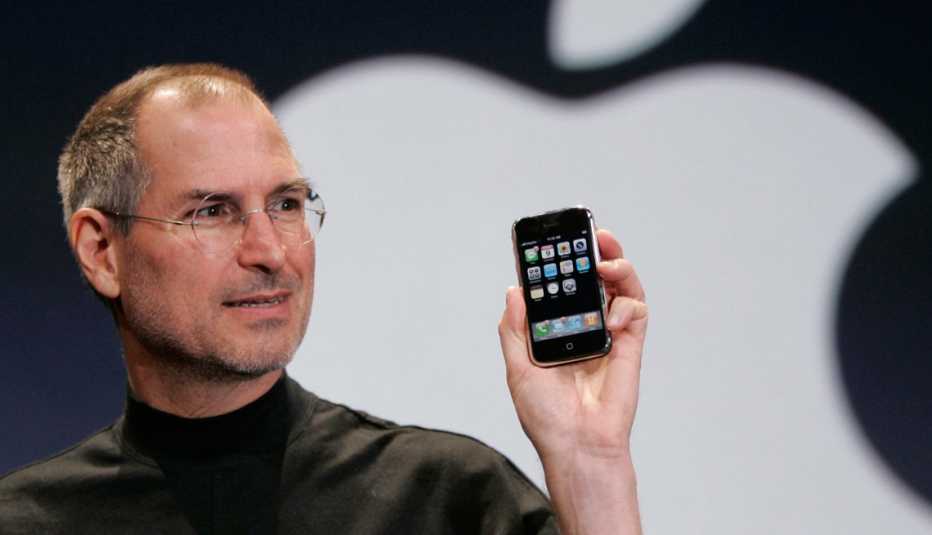 Steve Jobs sosteniendo un iPhone en sus manos