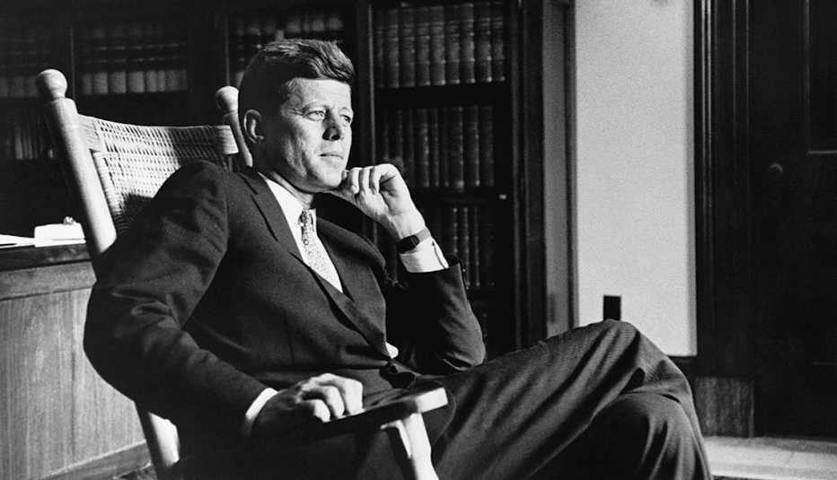 Presidente John F. Kennedy sentado en una silla mecedora en la oficina Oval de la Casa Blanca.