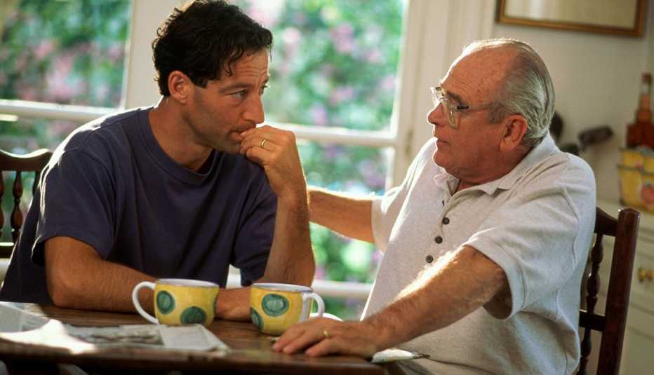Padre e hijo tomando café y hablando en casa