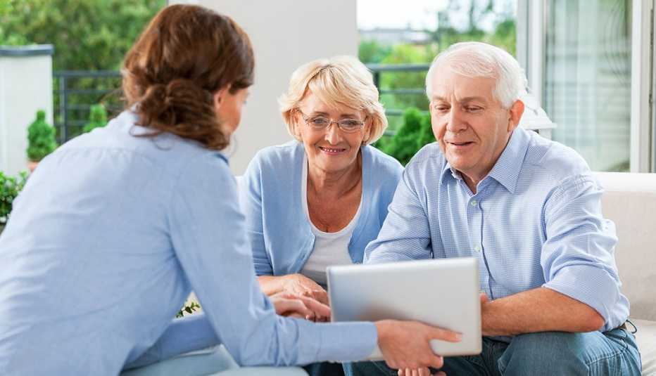 Una mujer asesora a una pareja de adultos mayores con sus documentos legales