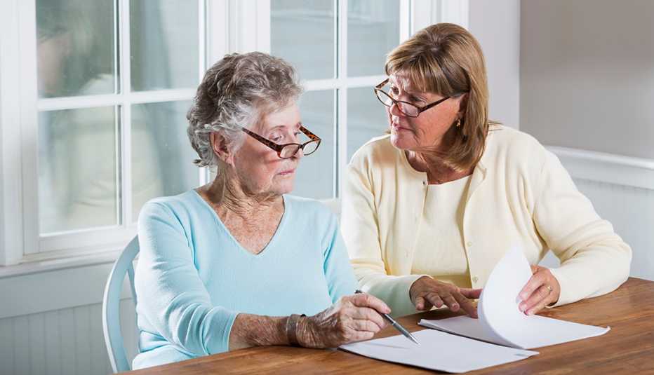 Dos mujeres conversan mientras revisan unos documentos
