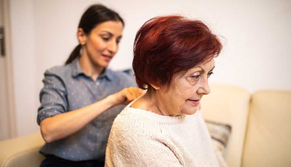 Una mujer joven le da un masaje a una mujer mayor