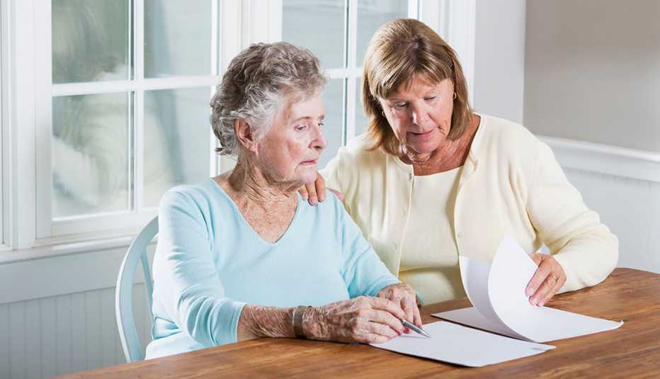 Una cuidadora familiar ayuda a su madre con documentos legales.