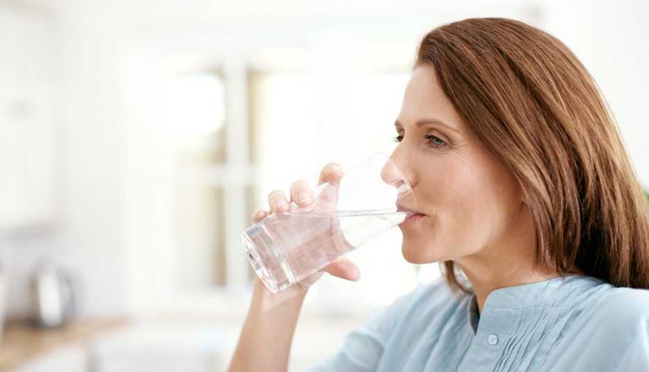 Una mujer tomando de un vaso de agua