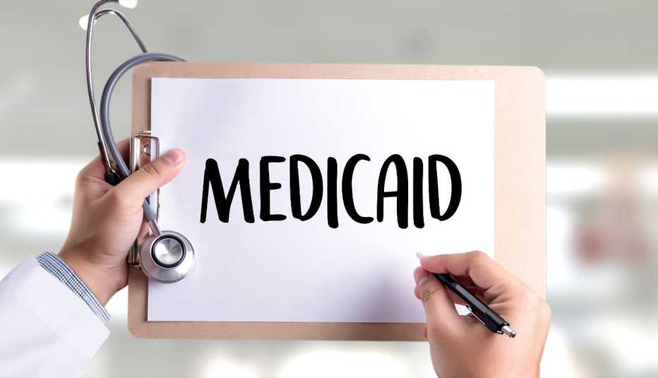 Médico sostiene un portapapeles con un papel que dice Medicaid