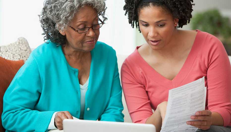 Mujer y su madre miran un documento