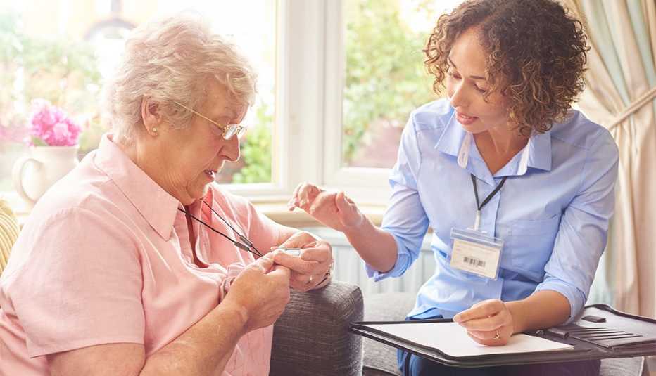Cómo elegir un sistema de alerta médica - Enfermera habla con una mujer mayor