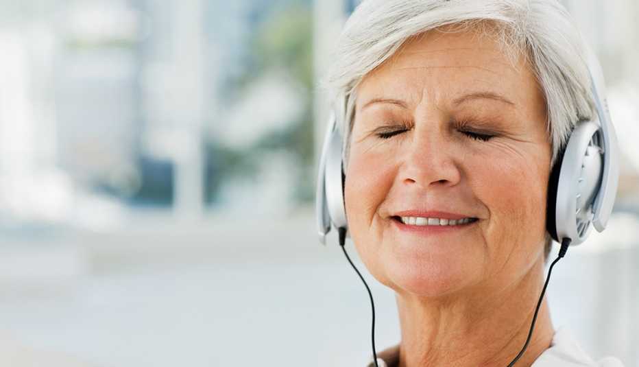 Mujer escuchando música con unos audífonos, el uso de la música para Controlar el Estrés