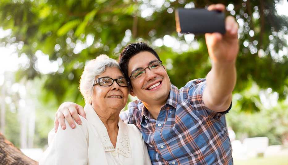 Un nieto y su abuela sonríen mientras se toman una selfie.
