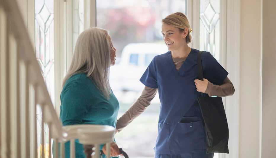 Enfermera conversando con una paciente en el frente de su casa