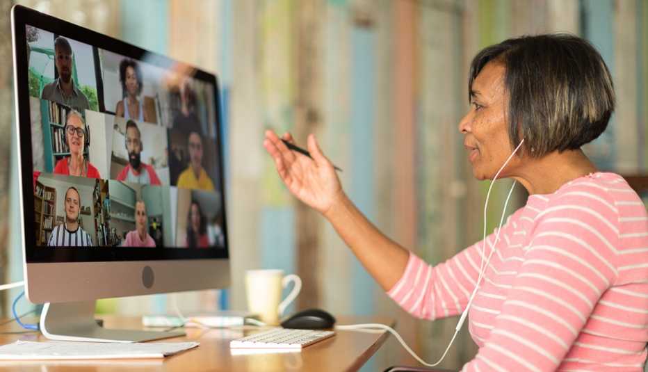 Una mujer cuidadora sentada en un escritorio trabajando durante una llamada de videoconferencia.