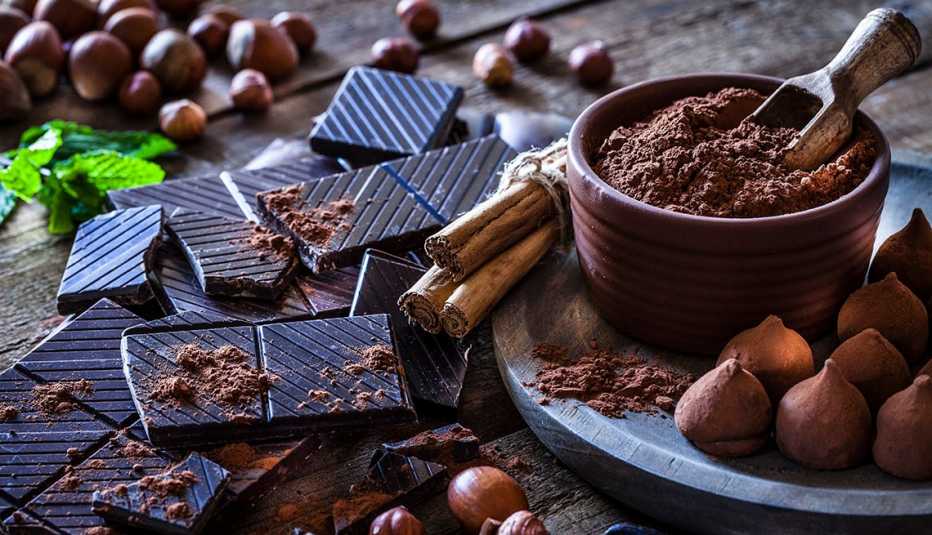 Mesa donde se ven trufas, barras de chocolate y cacao en polvo