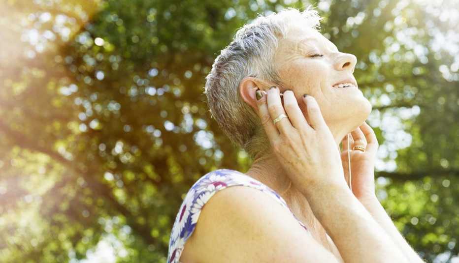 Mujer escuchando música con audífonos - Pérdida auditiva