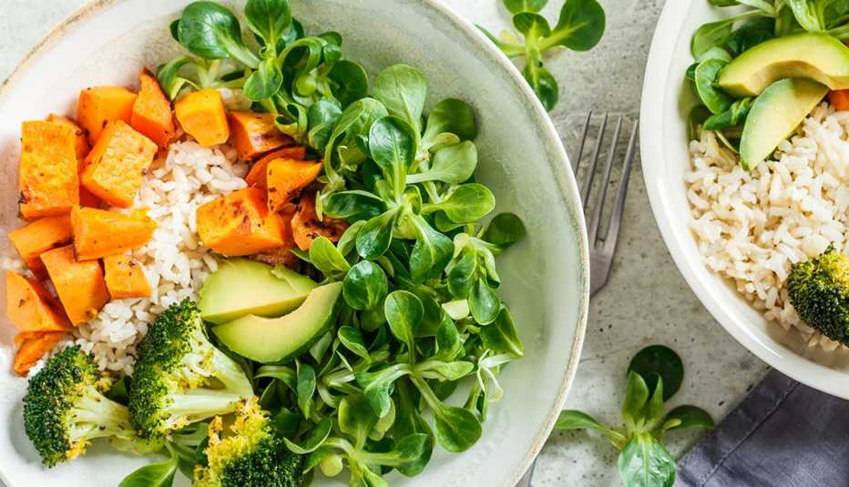 Almuerzo vegano con arroz integral, brócoli, camote, arroz y ensalada.