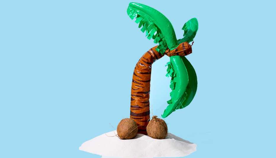 Figura de una palma de coco doblada y cocos en el suelo