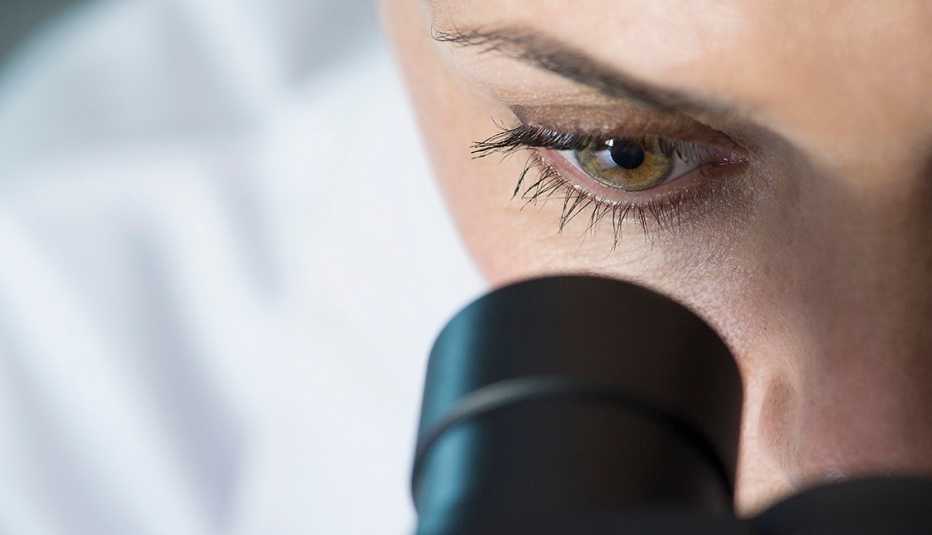 Médico mirando por el visor de un microscopio