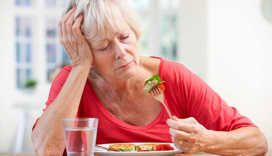 Mujer mayor intentando comer