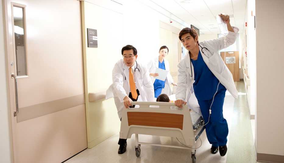 Tres médicos llevando a un paciente en camilla