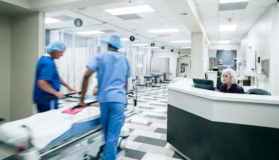 Enfermeros llevan una camilla por un pasillo de hospital