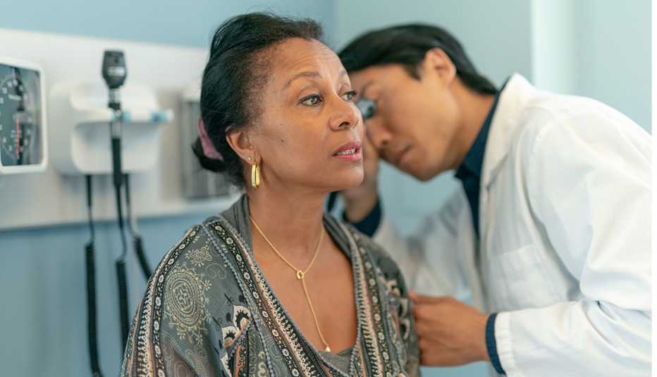 Un médico revisa los oídos de una mujer