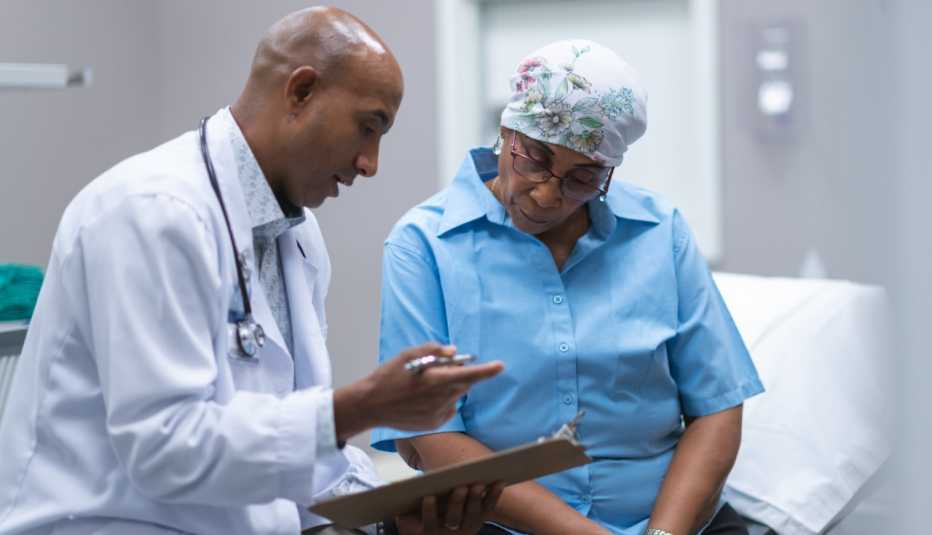 Una mujer afroamericana con cáncer hablando con su médico afroamericano