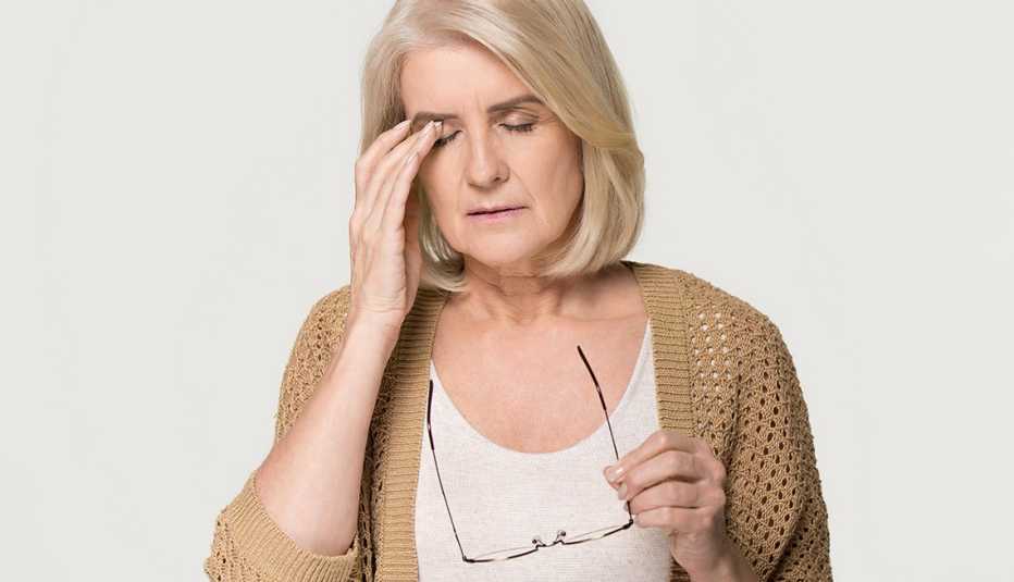 Una mujer se masajea su ojo derecho