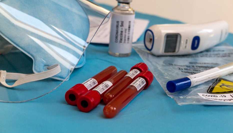 Tubos de ensayo con muestras de sangre sobre una mesa y otros artículos de laboratorio