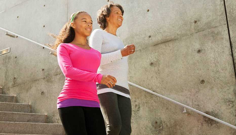 Madre e hija hacen ejercicio juntas bajando una escalera