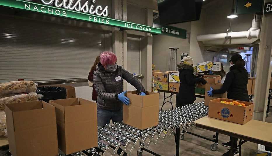 Voluntarios llenan cajas con alimentos en el vestíbulo del Wrigley Field en Chicago