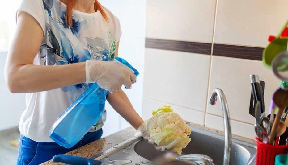 Una mujer desinfectando vegetales