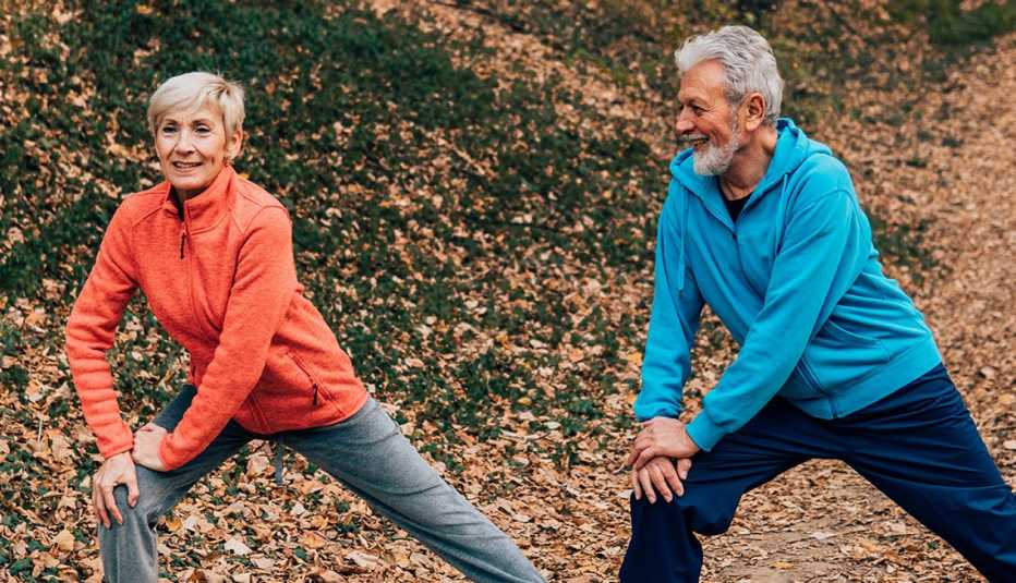 Una mujer y un hombre hacen ejercicios de estiramiento al aire libre