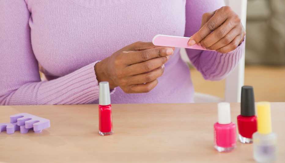 Manos de una mujer mientras se arregla las uñas.