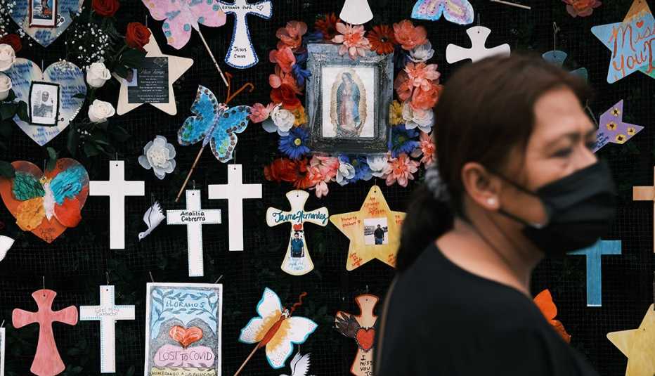 Una mujer camina frente a un memorial en honor a las víctimas de COVID