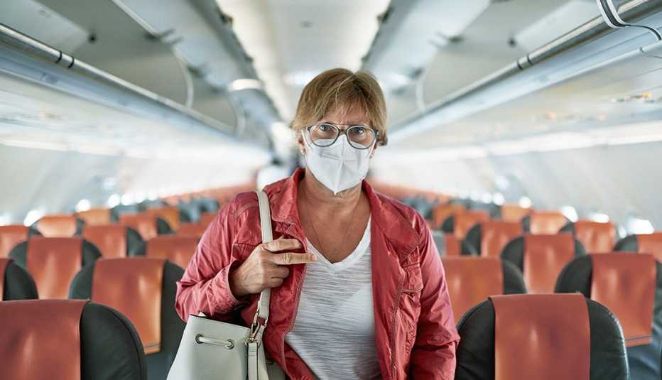 Una mujer, con mascarilla, dentro de un avión