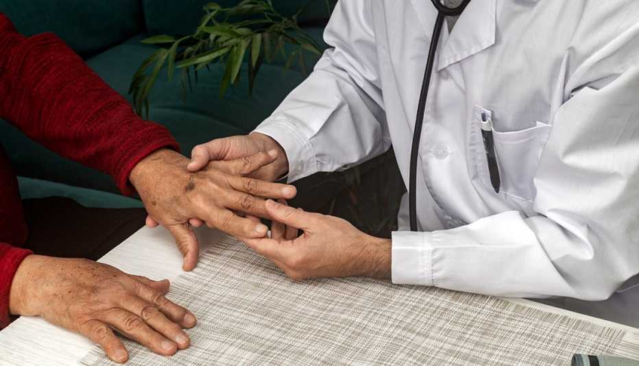 Un doctor examina la mano de un paciente