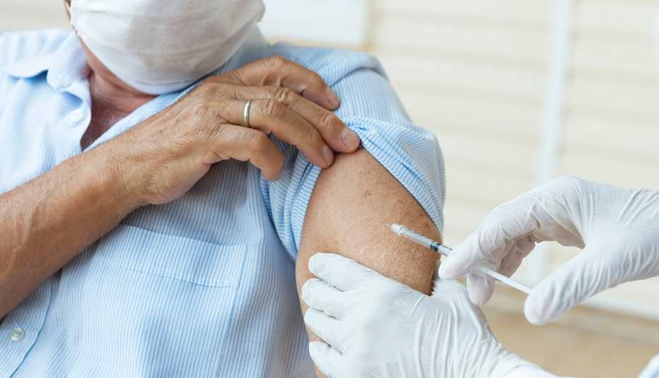 Un hombre recibe una vacuna en su brazo