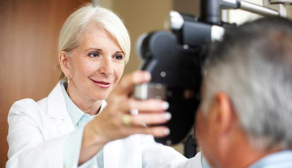 Una oftalmólogo usa un foróptero para revisar los ojos de un paciente