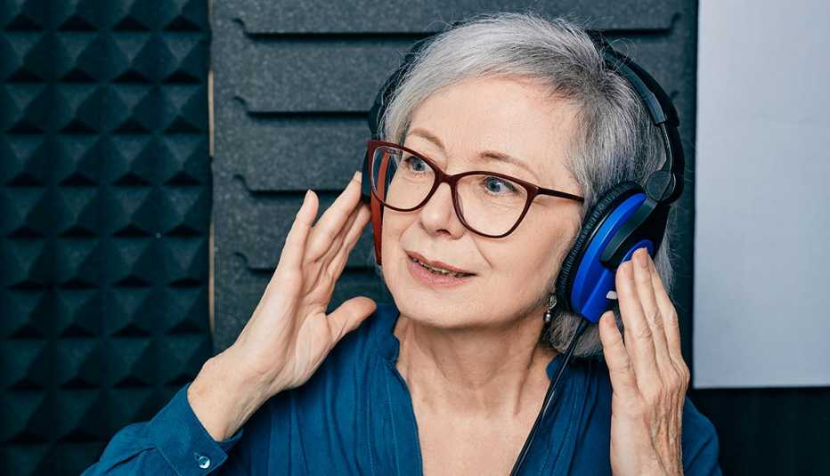 Una mujer con unos audífonos grandes azules se somete a una prueba de audición en una clínica
