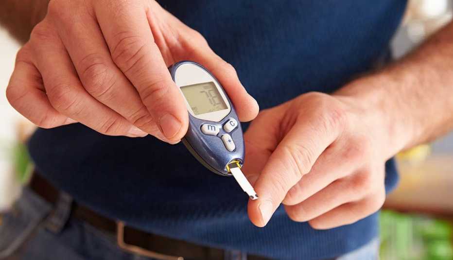 Hombre monitoreando su diabetes con un glucómetro