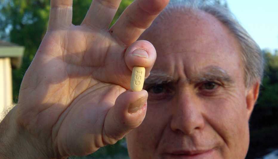 Hombre sosteniendo una píldora en su mano
