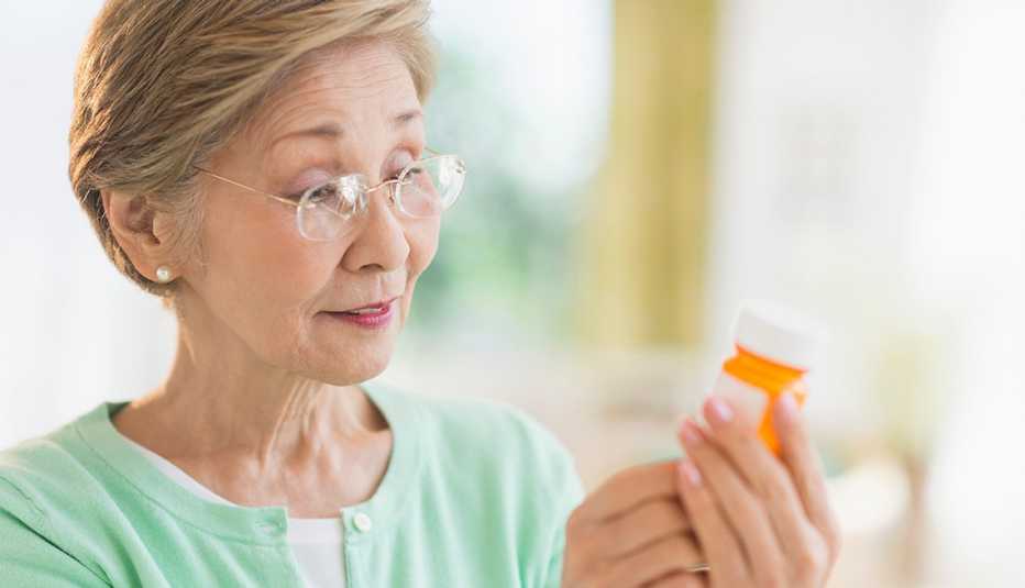 Una mujer mira la etiqueta de un medicamento