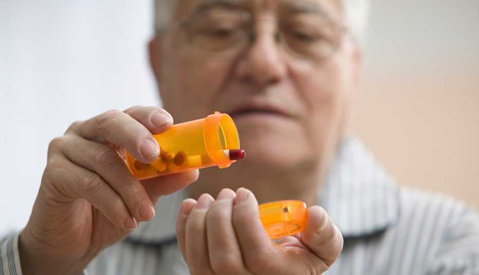 Hombre mayor preparándose para tomar su medicamento
