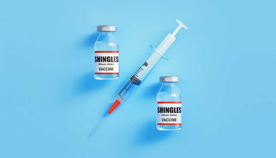 Dos frascos de vacunas contra la culebrilla y una jeringuilla sobre un fondo azul