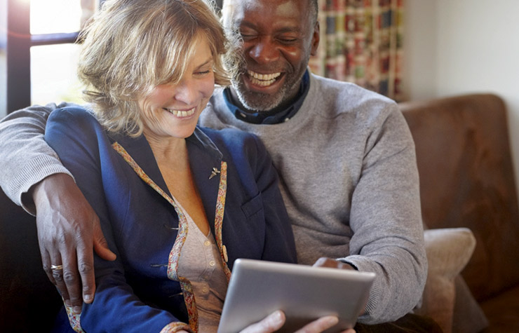 Una pareja usa una tableta digital en casa - Herramienta del Medicare de AARP
