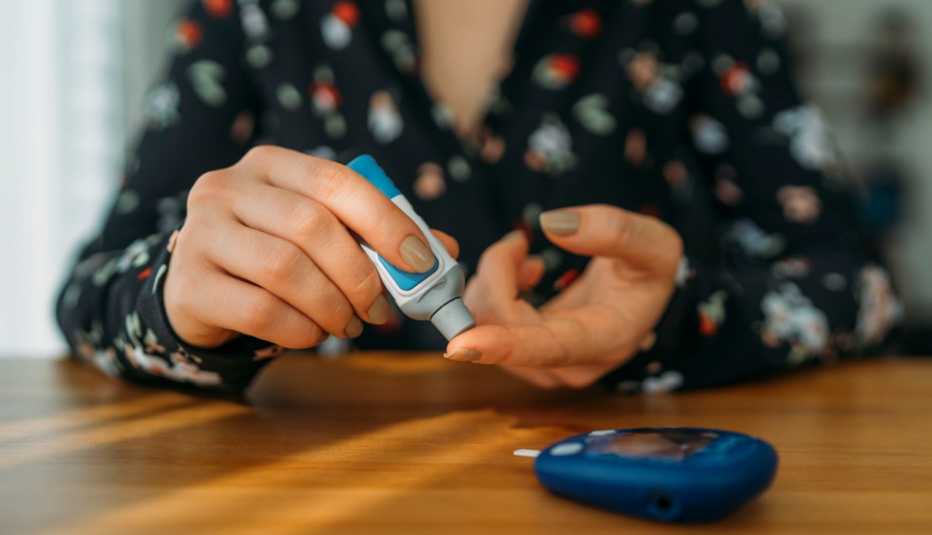 Una mujer pincha su dedo para medir su nivel de azúcar en la sangre