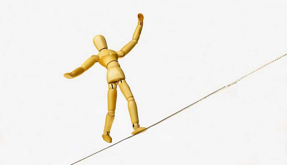 Marioneta mantiene equilibrio sobre una cuerda floja. 